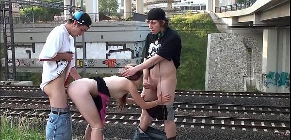  Cum in the mouth of a hot blonde teen girl in a public street sex threesome by a railway with 2 young guys doing blowjob cock sucking and vaginal penetration sexual intercourse with casual spectators watching this crazy screwing adventure